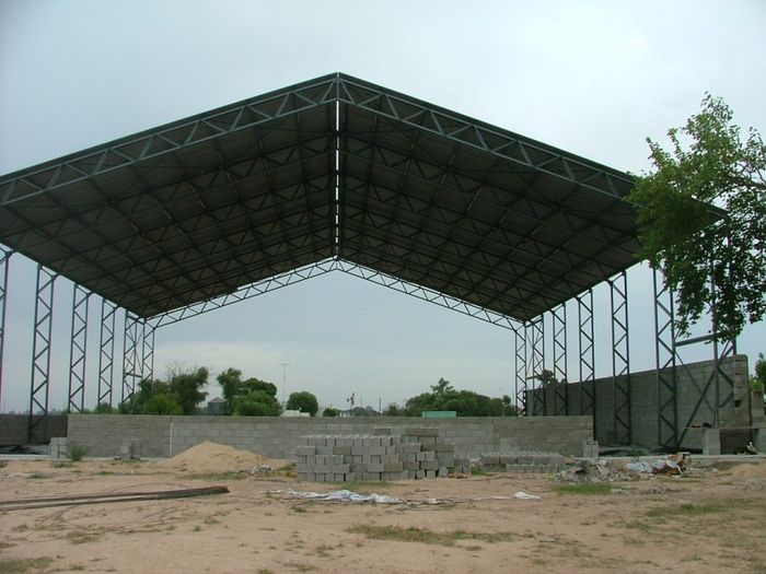 Nave industrial en construcción, estructura metálica sin cerramientos — Amione Construcciones, años 70