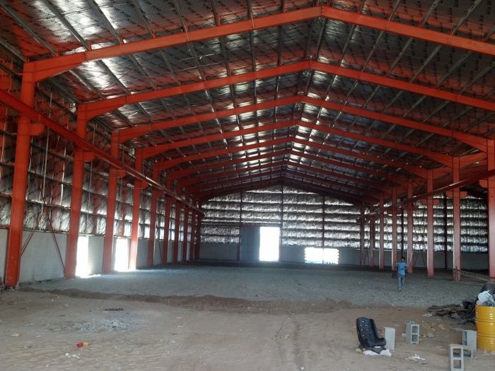 Interior de nave industrial terminada con estructura metálica pintada y techo aislado